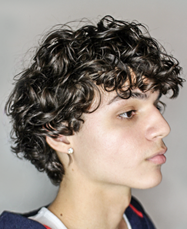 Side profile of a teenage male with textured, voluminous sea salt spray hair after styling with sea salt spray for hair. This "after" image demonstrates what does sea salt spray do for natural volume and definition, proving it's the best sea salt spray for men. It shows a great result, implying this good sea salt spray doesn't cause damage and works well for sea salt spray and curly hair, often found by searching sea salt spray near me.